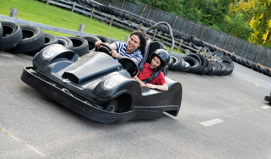 A go-kart with two riders speeds around the track at Broadway Grand Prix, Myrtle Beach Amusement Parks.