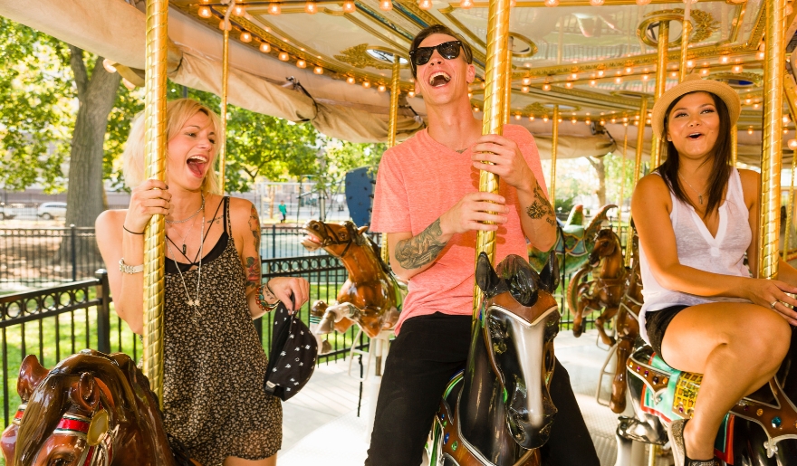 Three people enjoying a carousel ride at Family Kingdom Amusement Park in Myrtle Beach.