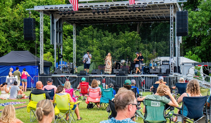 A lively crowd enjoying an outdoor concert at Conway Riverfest, seated on lawn chairs in Myrtle Beach.