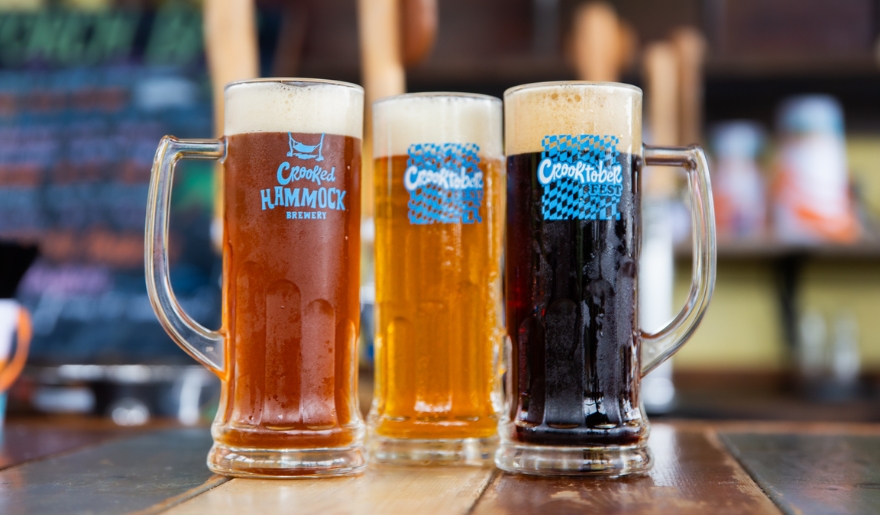 Three distinct beers at Crooked Hammock Brewing, promoting Crooktoberfest in Myrtle Beach.