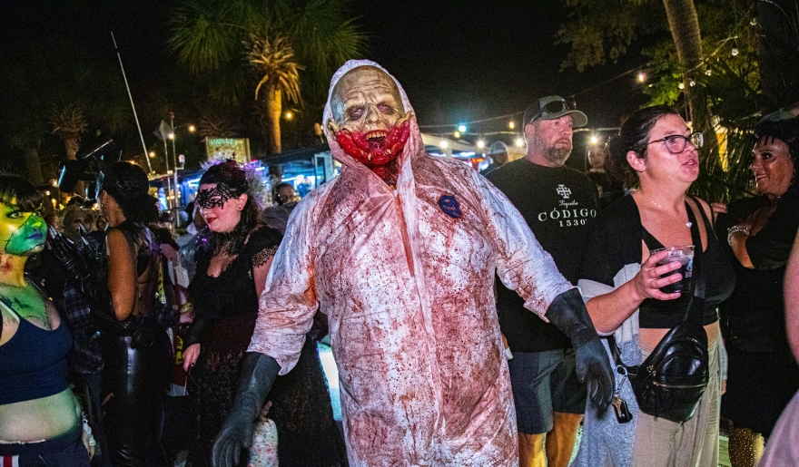 A group of individuals in zombie costumes parades down the street during Myrtle Beach's Halloween on the MarshWalk event.