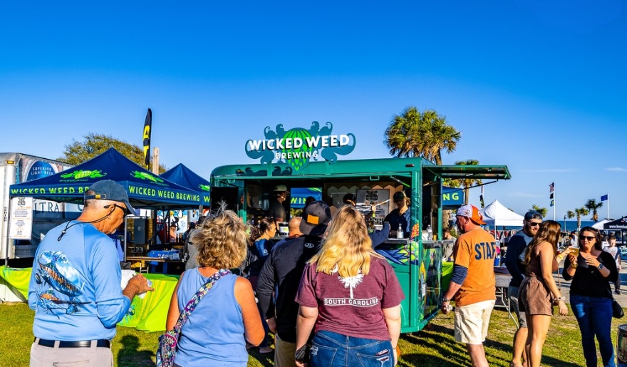 A crowd gathers around a food truck at the Myrtle Beach Food Truck Festival, enjoying diverse culinary offerings.