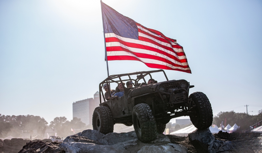 A jeep featuring an American flag, symbolizing pride at the Myrtle Beach Jeep Jam.