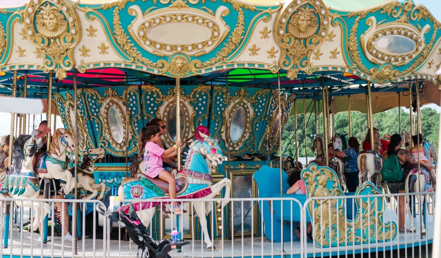 Children joyfully ride a colorful carousel at Family Kingdom Amusement Park during a Myrtle Beach family vacation.