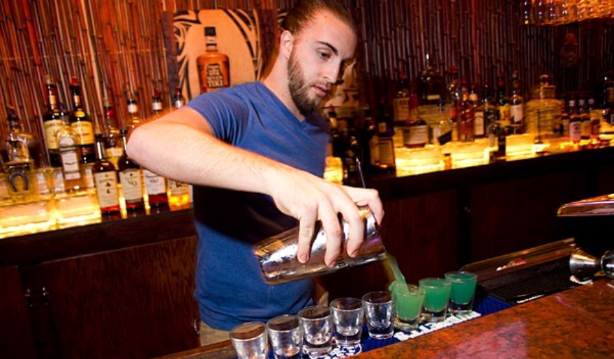  A man pours a drink at the 8th Ave Tiki Bar & Grill, capturing the vibrant nightlife of Myrtle Beach.