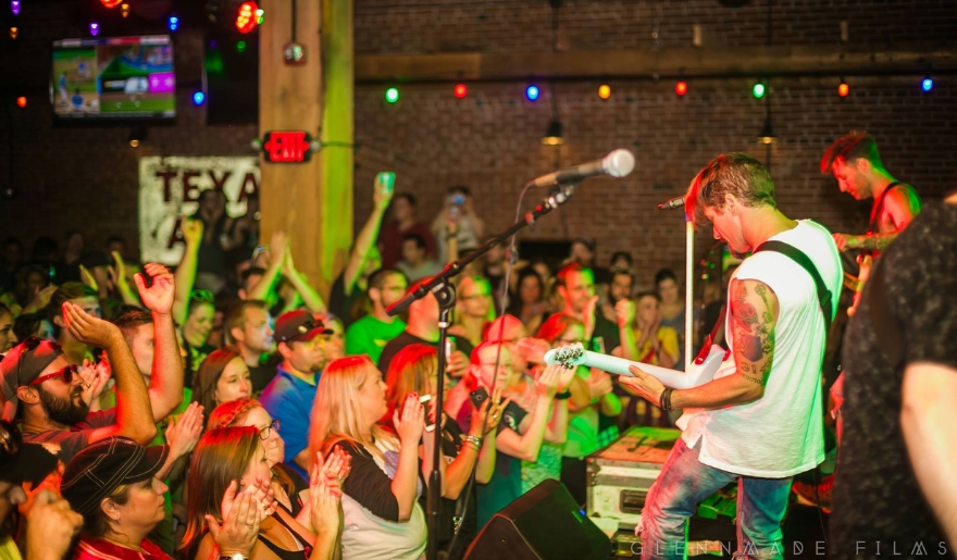 A lively band performs on stage at Tin Roof Myrtle Beach, with an enthusiastic audience enjoying the concert atmosphere.