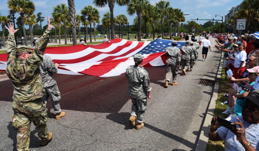 Military personnel proudly carry an American flag during Memorial Day celebrations in Myrtle Beach.