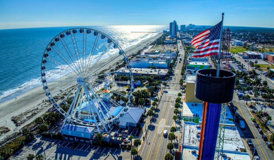 A vibrant view of Myrtle Beach featuring the iconic SkyWheel against a clear blue sky.