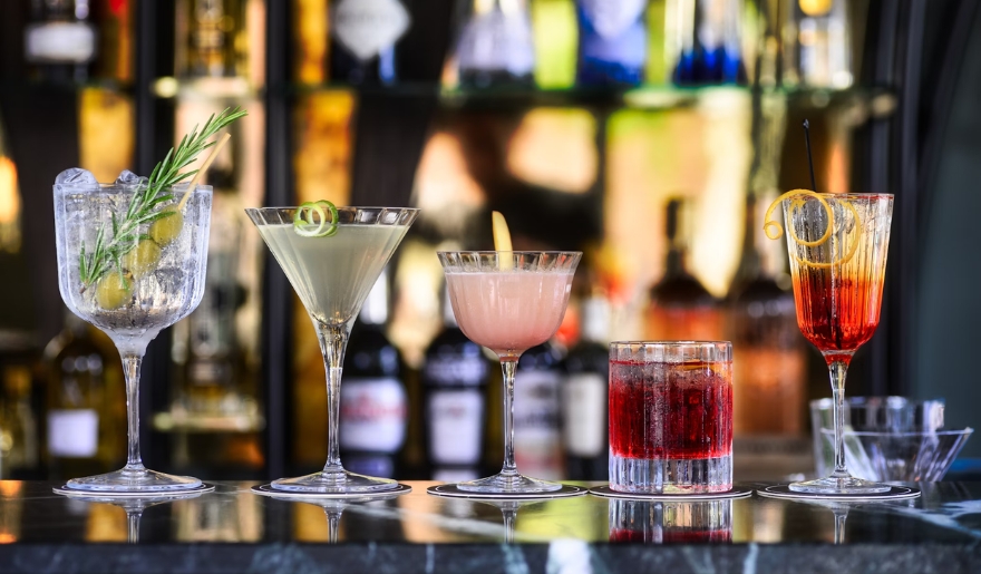 Various cocktails lined up on the bar at 8th Ave Tiki Bar & Grill, highlighting the vibrant atmosphere of Myrtle Beach nightlife.