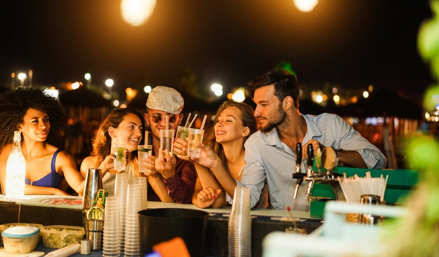 A lively group of friends enjoying drinks together at Ocean Annie’s Beach Bar in Myrtle Beach during the night.