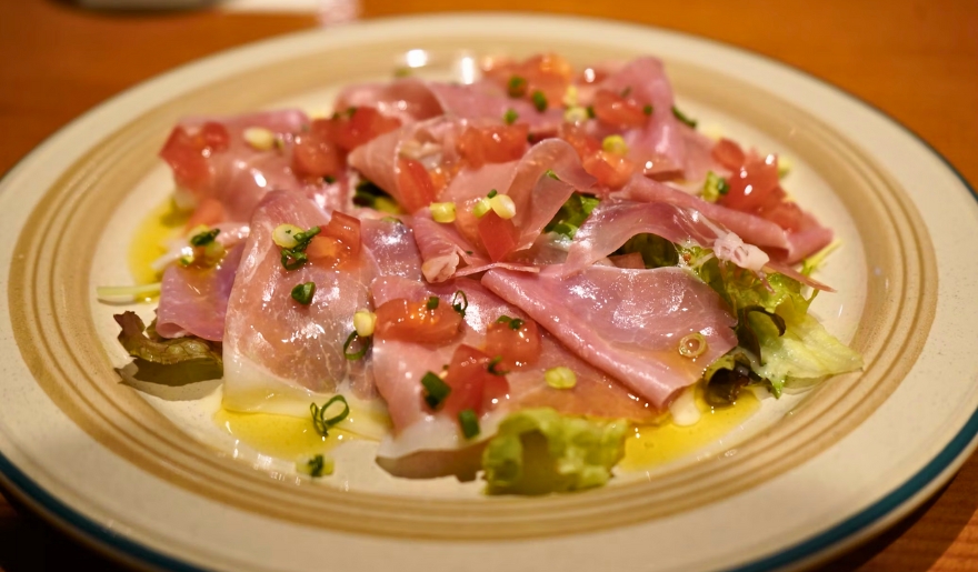 A vibrant plate of meat and fresh salad on a table, highlighting the dining atmosphere at Pine Lakes Tavern in Myrtle Beach.