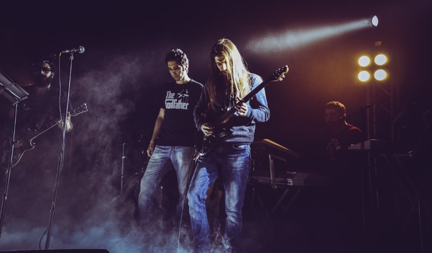The Bowery in Myrtle Beach features a band on stage, illuminated by vibrant lights and enveloped in smoke.