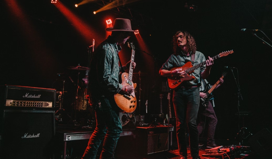 Two musicians playing guitars on stage during a concert at Tin Roof Myrtle Beach, highlighting the lively atmosphere.
