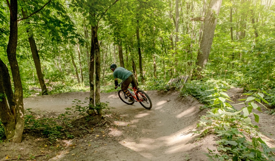 A cyclist navigates a mountain bike trail in the woods, highlighting Myrtle Beach's outdoor adventure options.