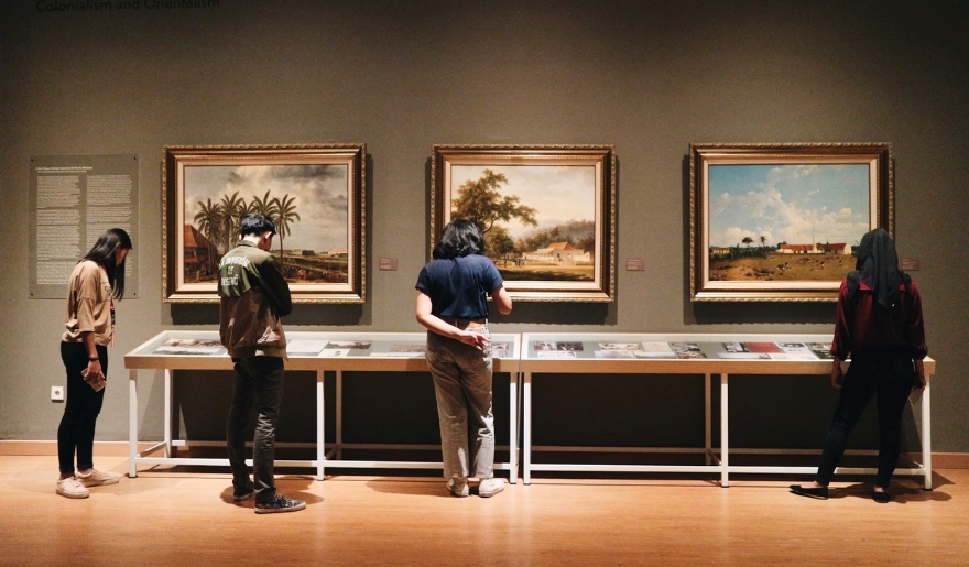 People engage with artwork in an art museum, highlighting Myrtle Beach's rich local culture and history.