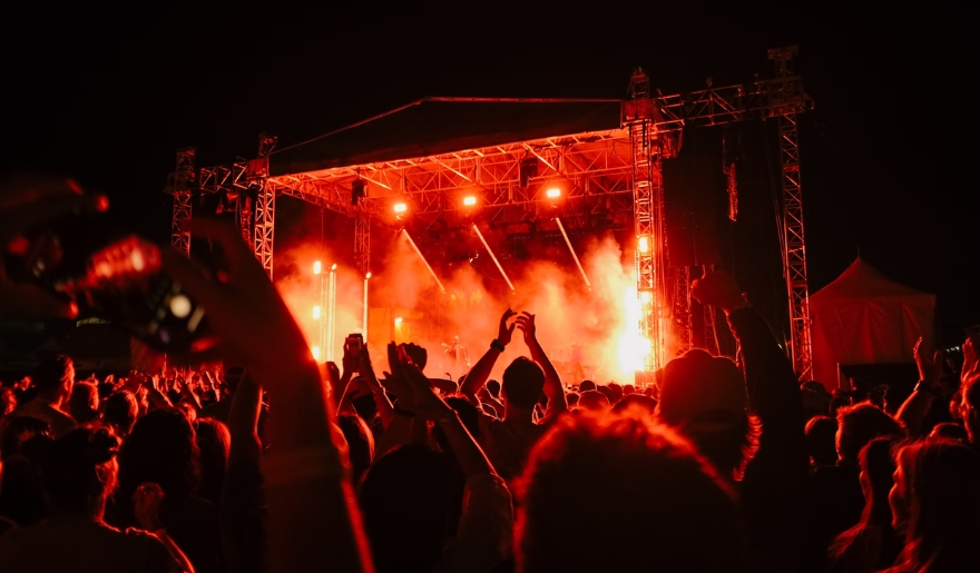 A lively crowd at a concert illuminated by red lights, showcasing Myrtle Beach's vibrant nightlife scene.
