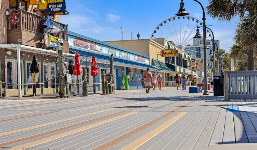 People walking along a lively boardwalk at Myrtle Beach, ideal for a weekend escape.