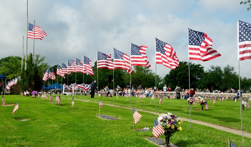 A cemetery in Myrtle Beach adorned with American flags and graves, honoring Memorial Day Weekend in May.