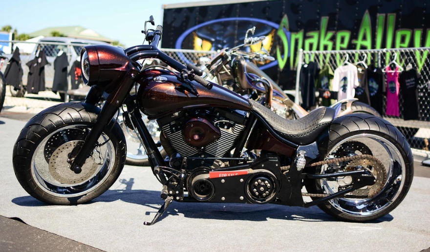A motorcycle is parked next to a tent on the pavement at Myrtle Beach Bike Week Spring Rally in May.