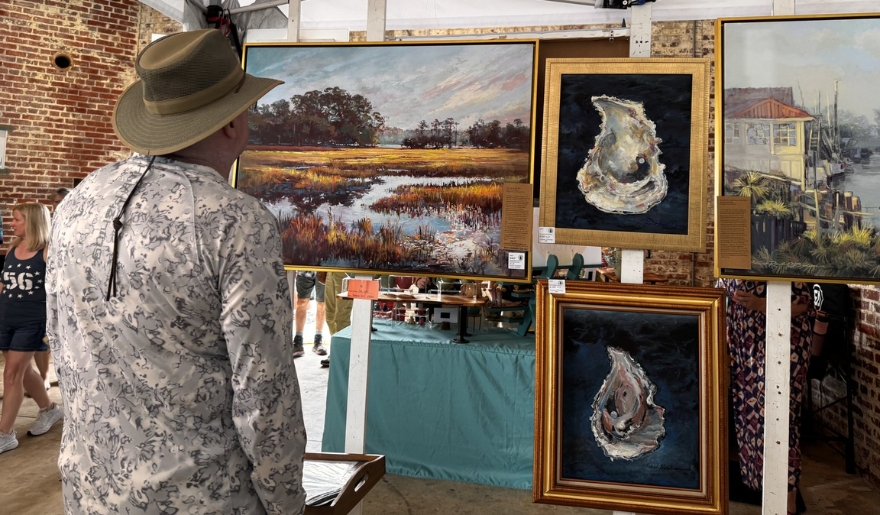 A man wearing a hat admires artwork on display at the Atalaya Arts & Crafts Festival in Myrtle Beach, September.