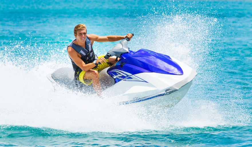 A man skillfully rides a jet ski in the ocean at Myrtle Beach during September, capturing the essence of summer fun.