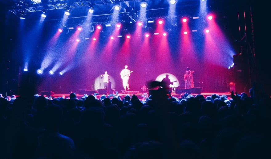 A lively audience at a concert in Myrtle Beach, with colorful lights shining, showcasing September's live entertainment events.