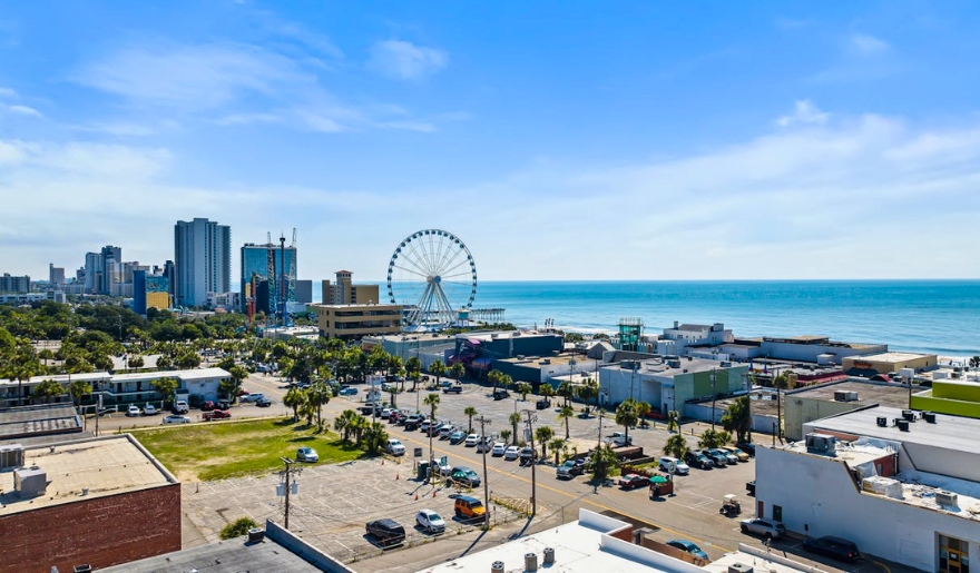 Overlooking the ocean and Ferris wheel from a building, capturing the lively atmosphere of Myrtle Beach in summer.