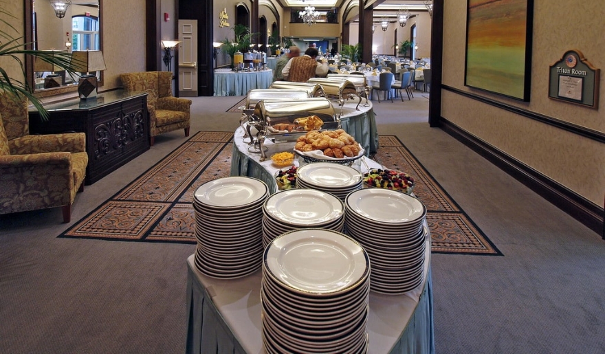 A buffet table filled with various dishes and plates, set up for an event in Marina Inn at Myrtle Beach.