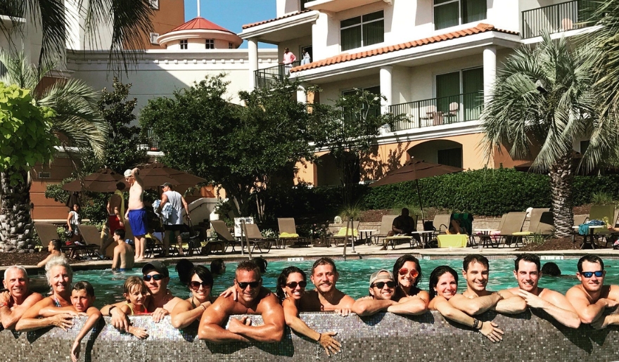 A joyful group poses for a picture in front of a pool at Marina Inn, Myrtle Beach, during a family reunion.