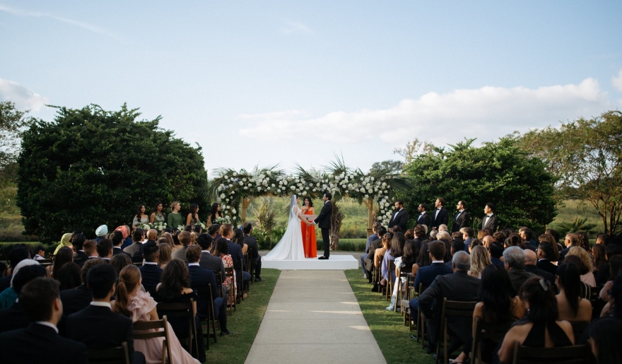 A wedding ceremony at the Marina Inn, showcasing an elegant setup with floral decorations and guests seated in anticipation.