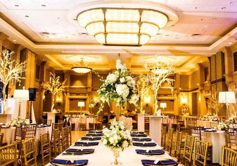 A wedding reception featuring elegant gold and blue decor in a beautifully arranged indoor venue at Marina Inn in Myrtle Beach, SC.