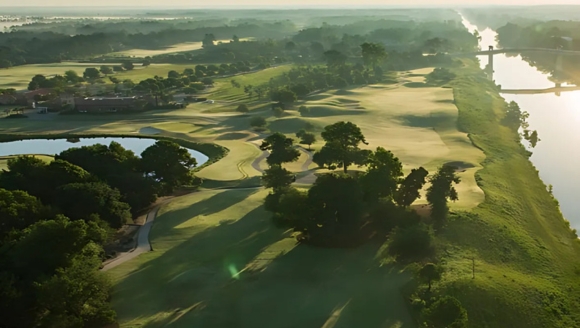Aerial view of Grande Dunes Golf Club in Myrtle Beach, SC, showcasing a golf course with trees and water features.