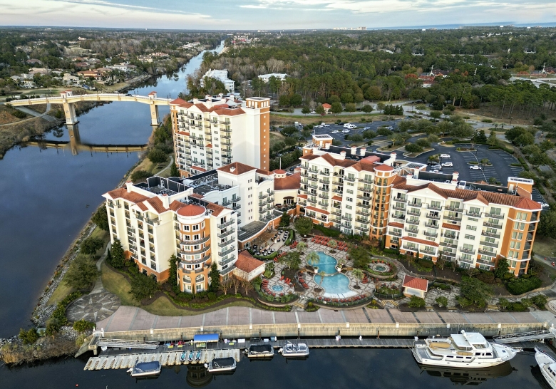 Aerial view of a resort and marina in Myrtle Beach, SC, showcasing outdoor lawn party areas for birthday celebrations.
