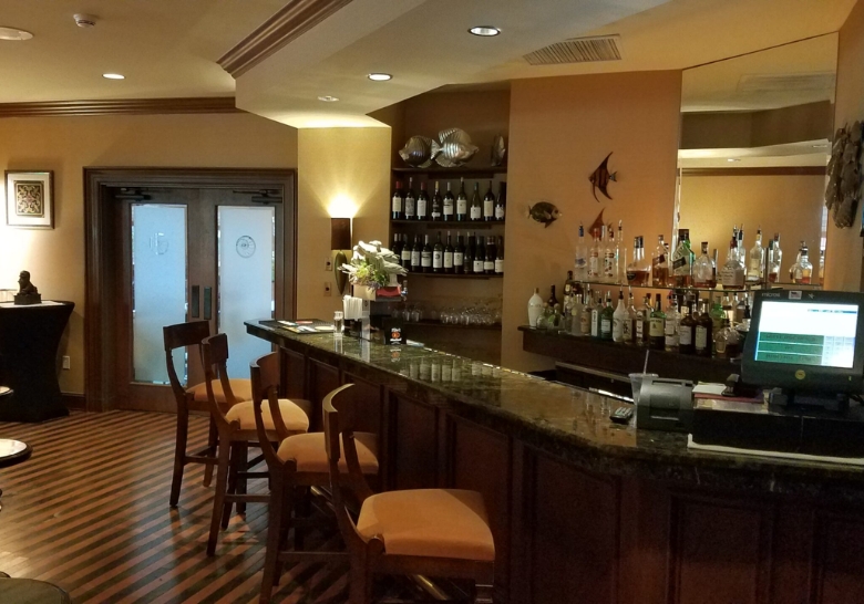 A cozy bar with wooden flooring and bar stools, advertising catering services in North Myrtle Beach, SC.