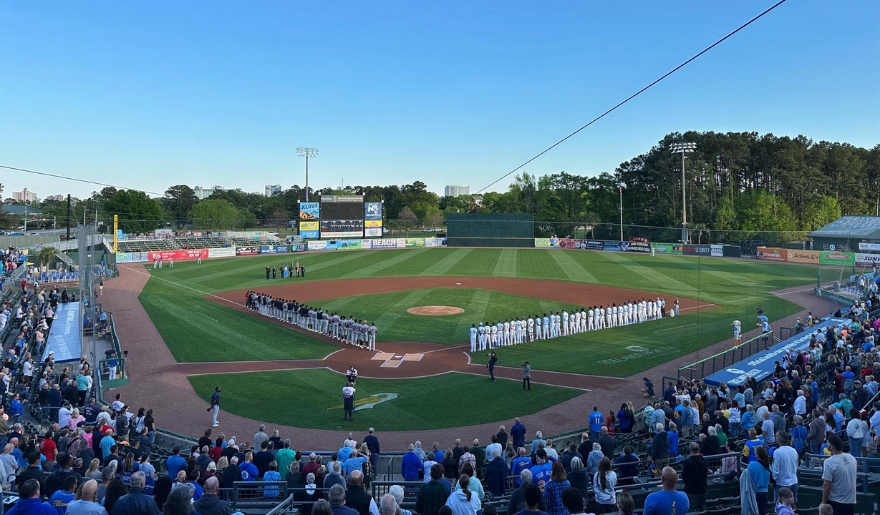 A crowded baseball field at Myrtle Beach in August, with fans watching a game featuring the Myrtle Beach Pelicans.