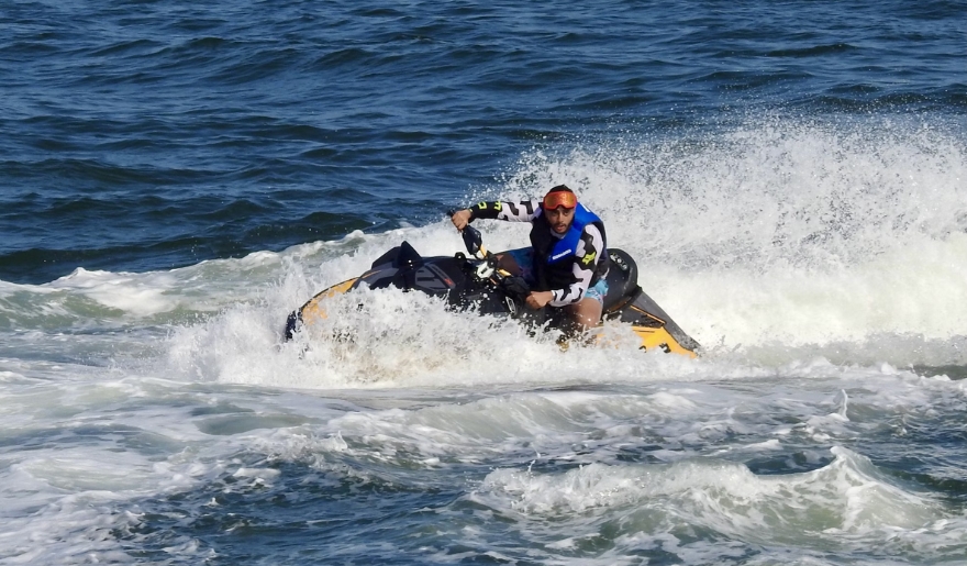 A man on a jet ski glides across the ocean waves at Myrtle Beach in August, showcasing summer water sports.