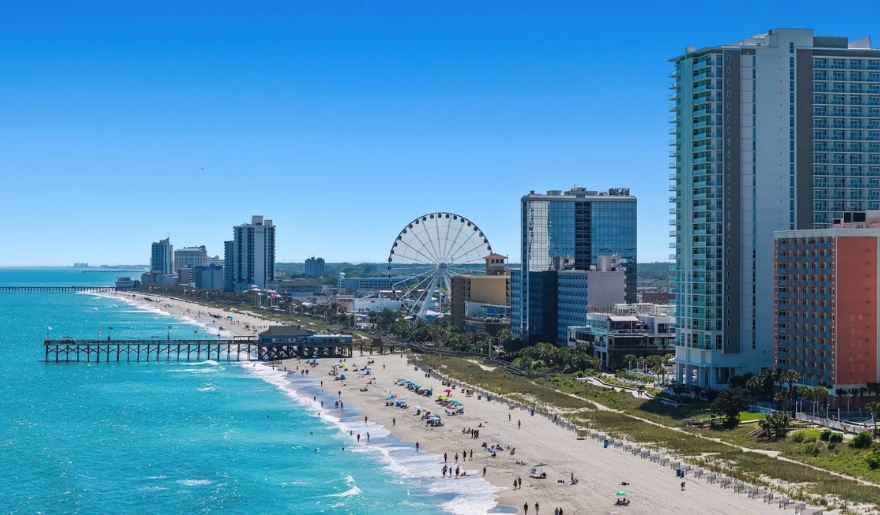 A sunny day at Myrtle Beach, SC in August, showcasing the beach, ocean, and clear blue skies.
