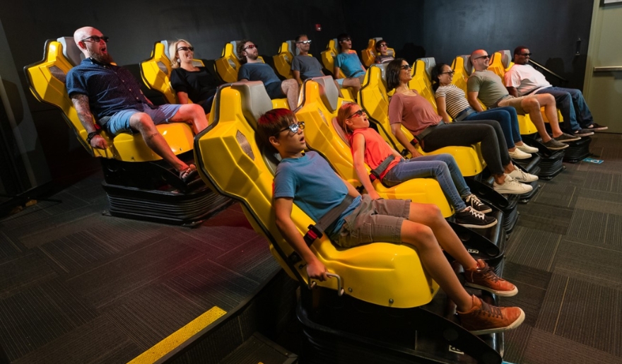 A group of people sitting together in a yellow chair at WonderWorks, showcasing the indoor adventures in Myrtle Beach during August.