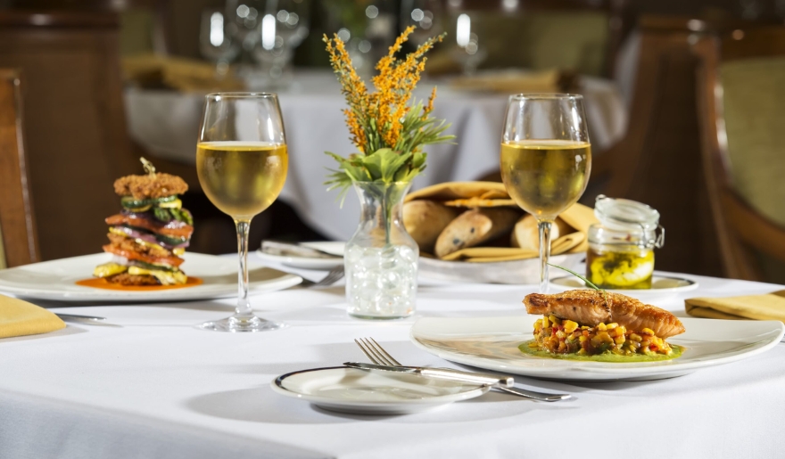 A table at WaterScapes Restaurant in Myrtle Beach, featuring two plates of food and two glasses of wine in June.
