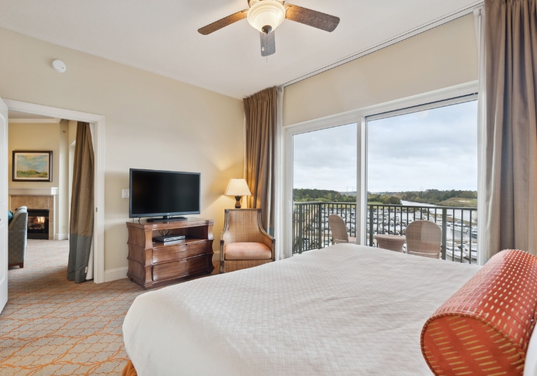 Stylish bedroom showcasing a large bed and flat-screen TV, designed for luxury guest experiences in Myrtle Beach, SC.
