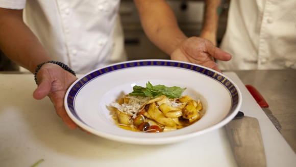 Two chefs present a bowl of food on a counter at a private dining space for a birthday party in Myrtle Beach, SC.