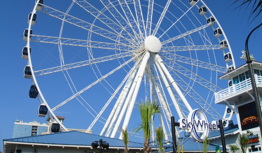 The Myrtle Beach SkyWheel towers over a building, inviting visitors to enjoy a festive ride during the holidays.