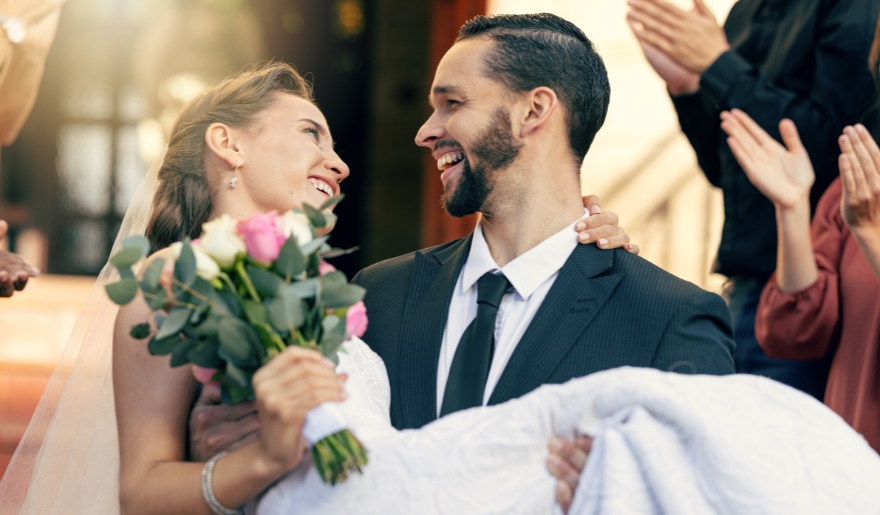 A happy couple in wedding attire holds each other closely, smiling at Myrtle Beach during their celebration at Eri Boo's Fresh Brunch.
