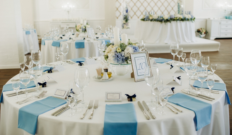 A wedding reception table adorned with blue and white tablecloths at Golden Luxe Venue in Myrtle Beach.