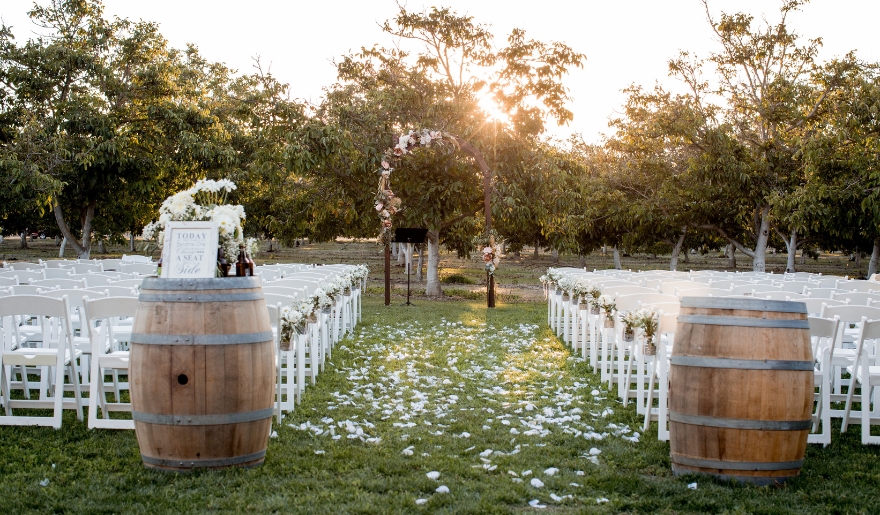 Outdoor wedding ceremony at La Belle Amie Vineyard, featuring wooden barrels and chairs set up for guests.