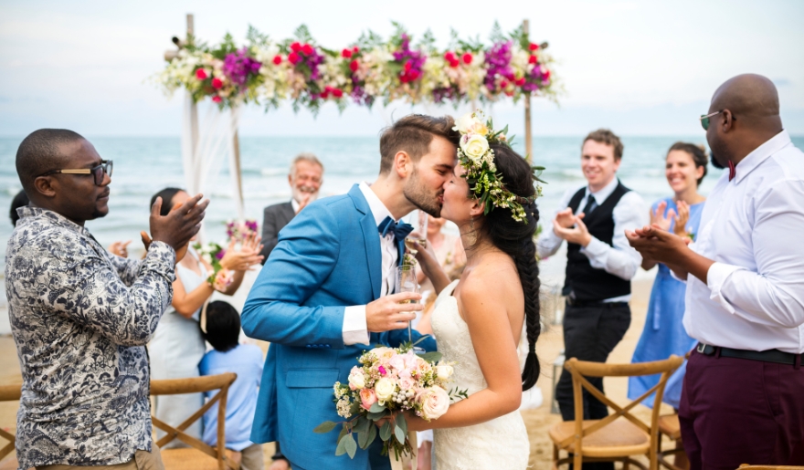 A bride and groom share a kiss on the beach during their wedding ceremony at Myrtle Beach, hosted by Simple Wedding Day, LLC.