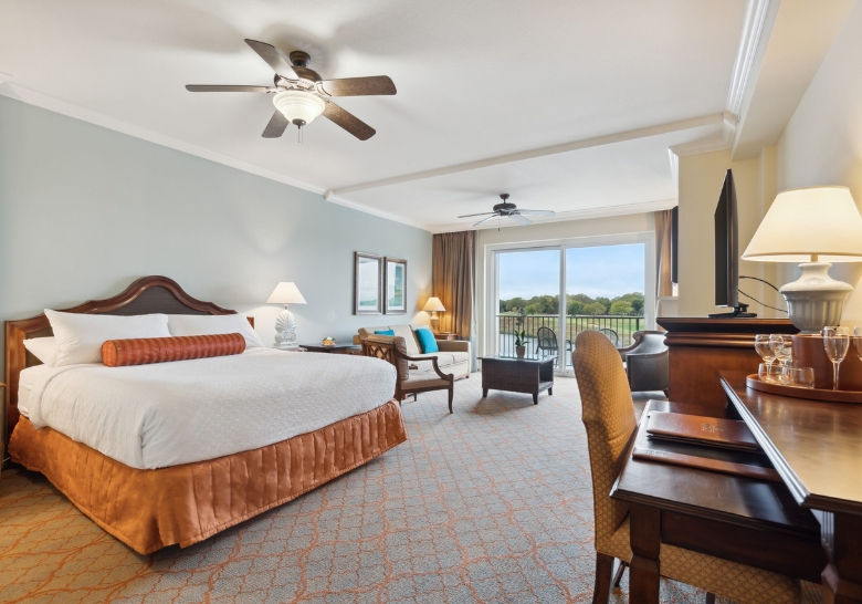 A spacious hotel room featuring a king bed, desk, and television, designed for comfort and tranquility in Myrtle Beach.