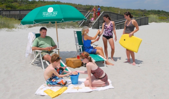A family enjoying a sunny day at Myrtle Beach, surrounded by umbrellas and chairs at a kid-friendly resort.