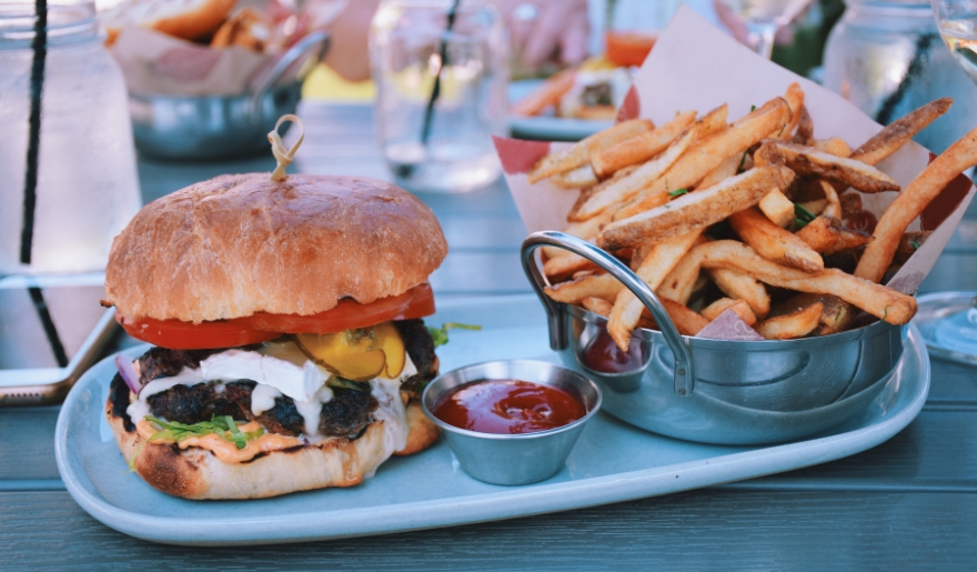 A hamburger and a side of french fries on a plate, showcasing a meal option for families at The Hangout in Myrtle Beach.