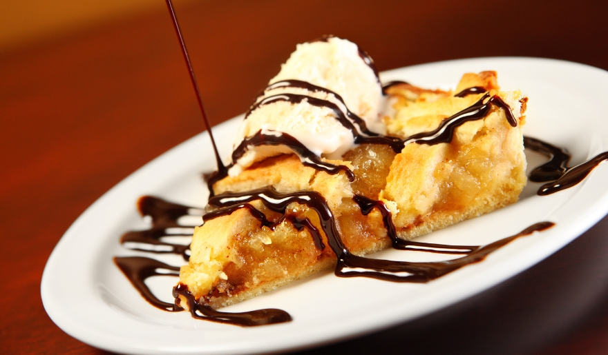 A chocolate-drizzled slice of pie on a plate, showcasing a sweet treat available at LuLu's NMB in Myrtle Beach.